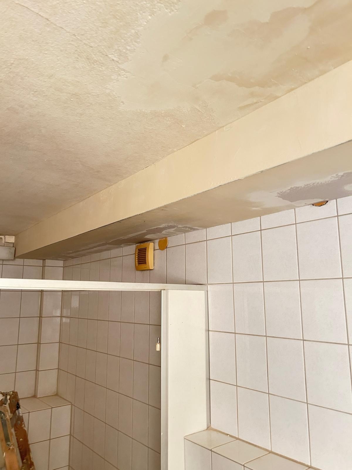 Wasserschaden an der Bad-Decke vor der Sanierung, sichtbare Feuchtigkeitsspuren